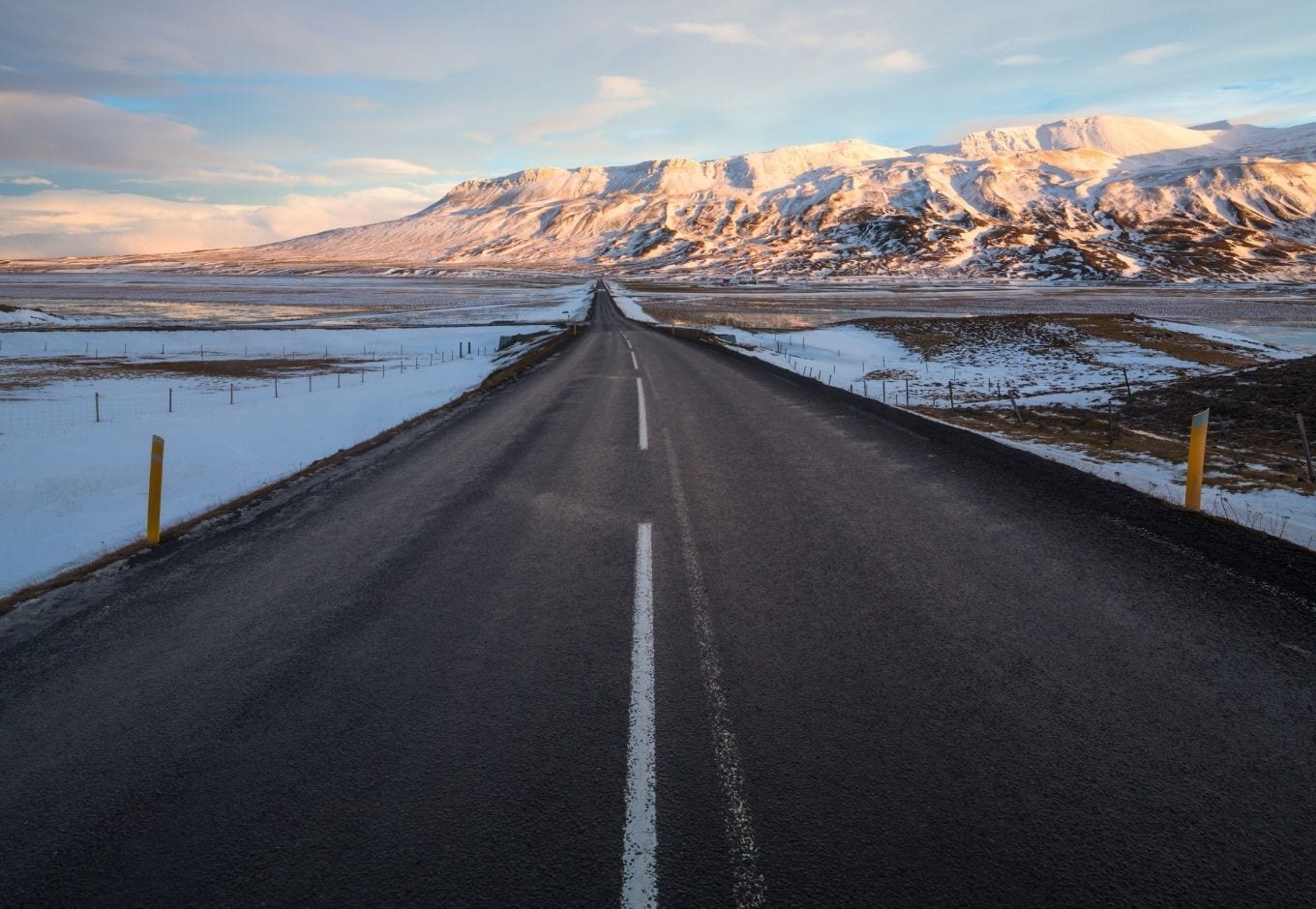 The Ring Road leading to a range of snowy mountains, in Iceland.